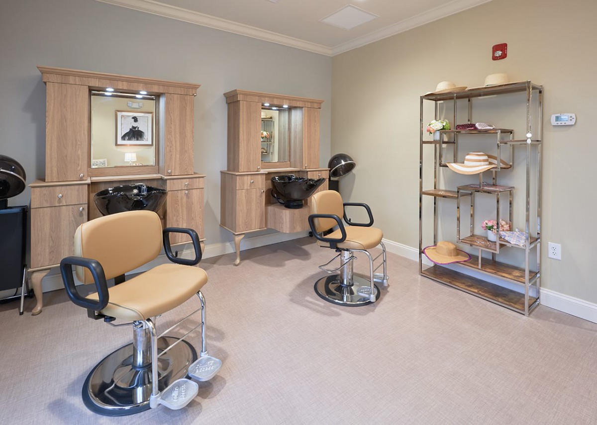 An empty hair salon with styling chairs and mirrors.