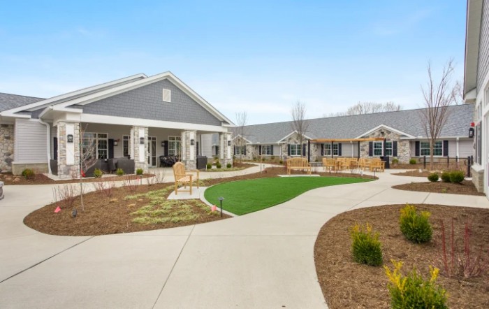A modern building with a landscaped garden and pathway.