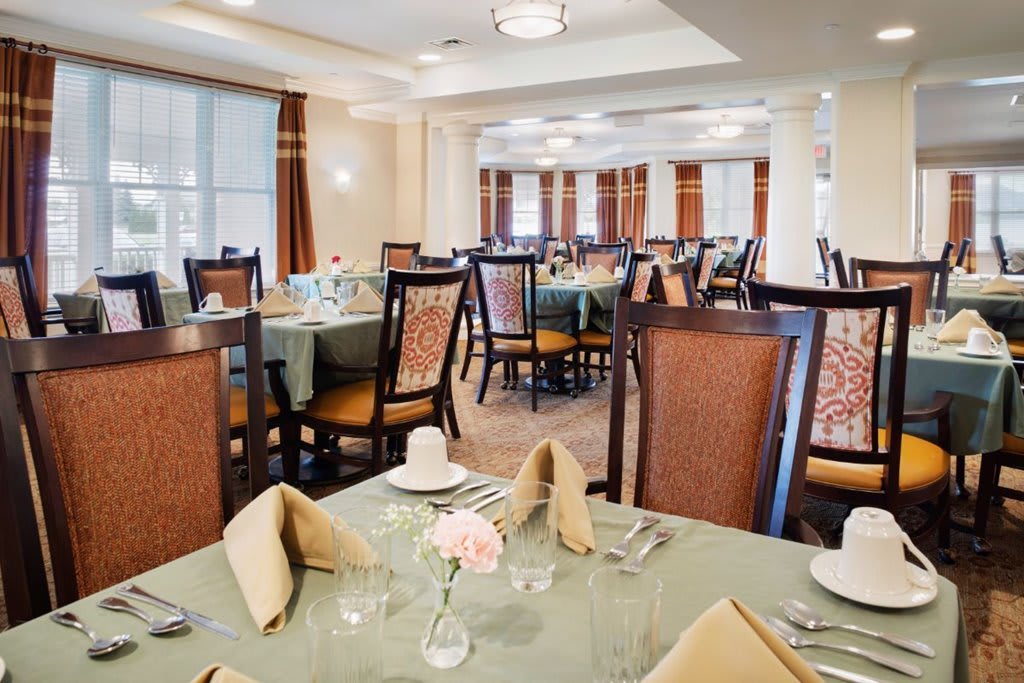 An elegant restaurant dining room with neatly set tables and comfortable chairs.