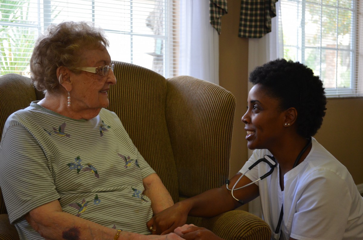 A nurse providing compassionate care to an elderly person in a comfortable setting.