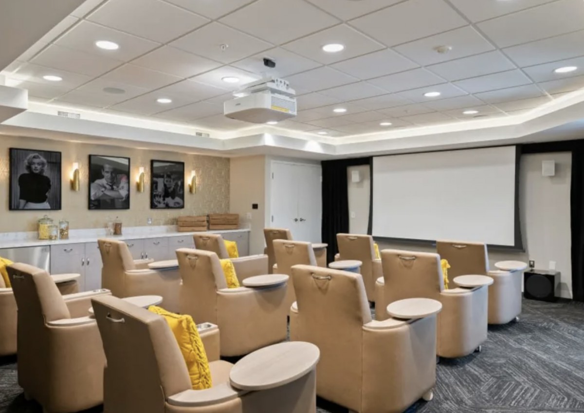 A modern conference room with comfortable seating and a projection screen.