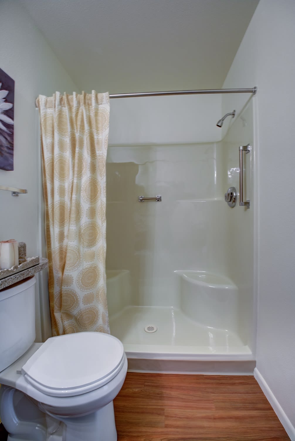 A modern bathroom featuring a shower with a patterned curtain and a toilet.
