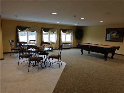 A cozy games room featuring a pool table and seating area.