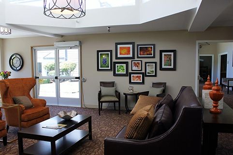 A modern living room featuring a seating area with sofas and chairs, complemented by a coffee table and a wall adorned with colorful artwork.