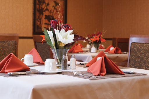 A beautifully arranged dining table featuring a floral centerpiece and neatly folded napkins.