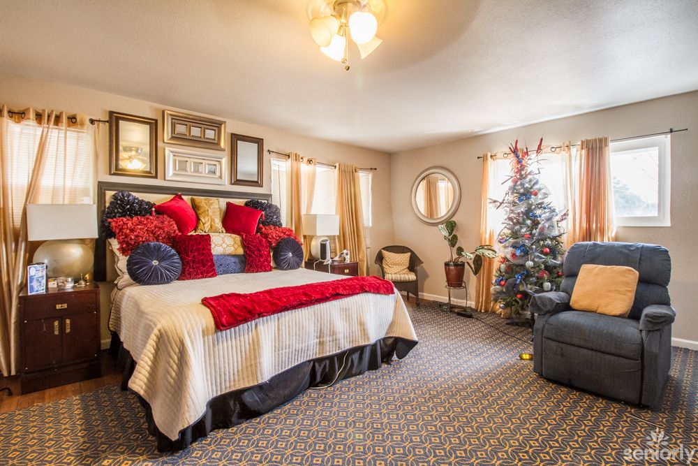 Cozy bedroom with festive Christmas decorations and colorful pillows.