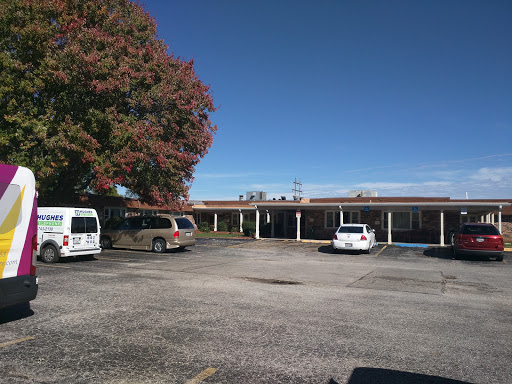 A view of a building with a parking lot and clear blue sky.
