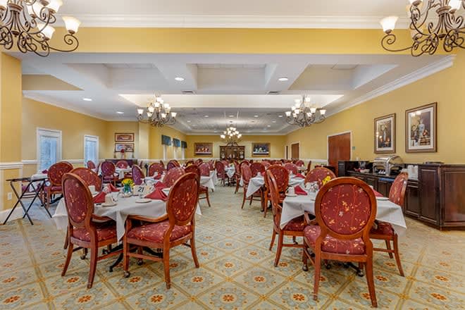 A spacious and elegantly decorated dining room with neatly arranged tables and chairs.