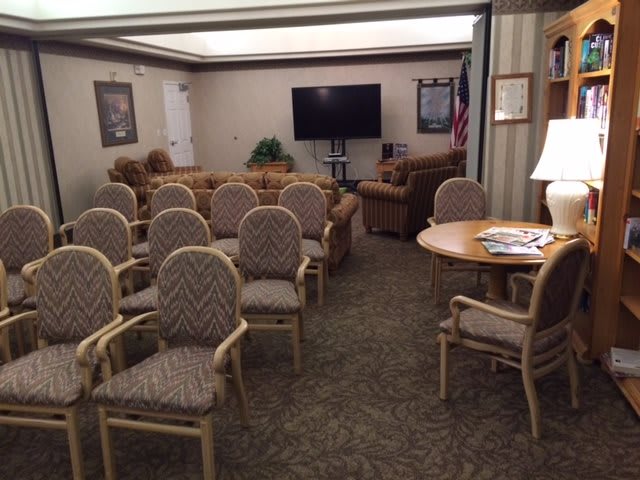 A conference room with arranged seating and a television for meetings.