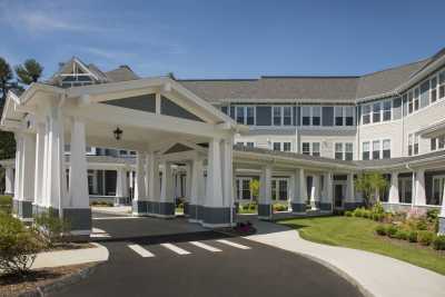 A beautifully designed building with a grand entrance and well-maintained landscaping.