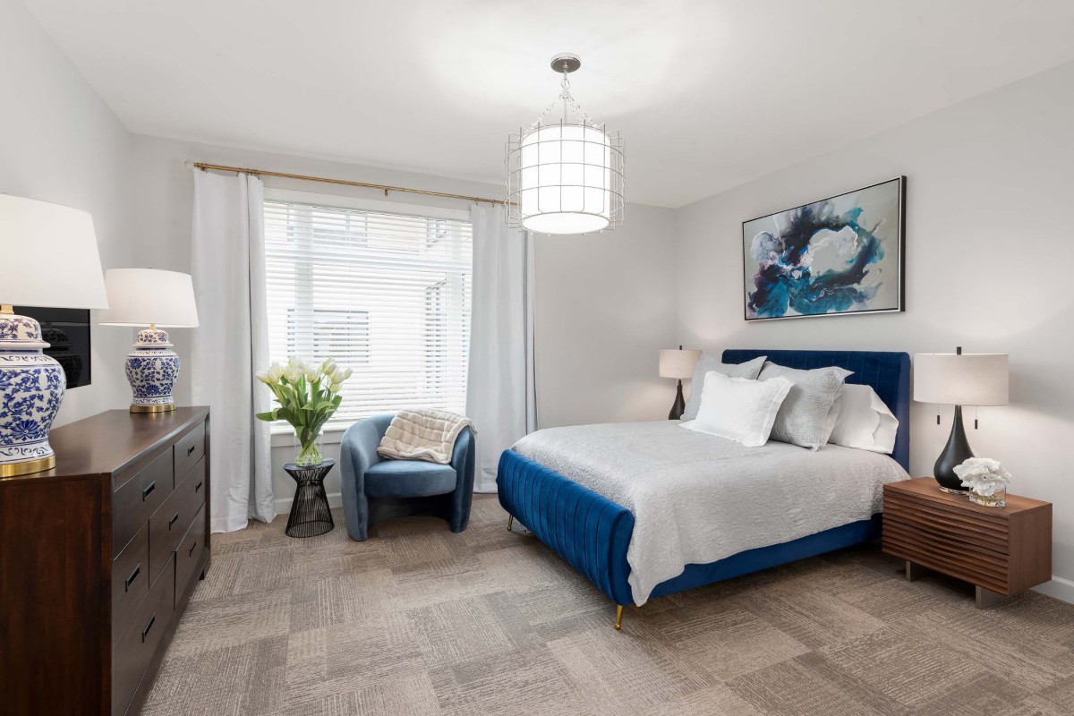 A modern bedroom with blue accents and contemporary decor.
