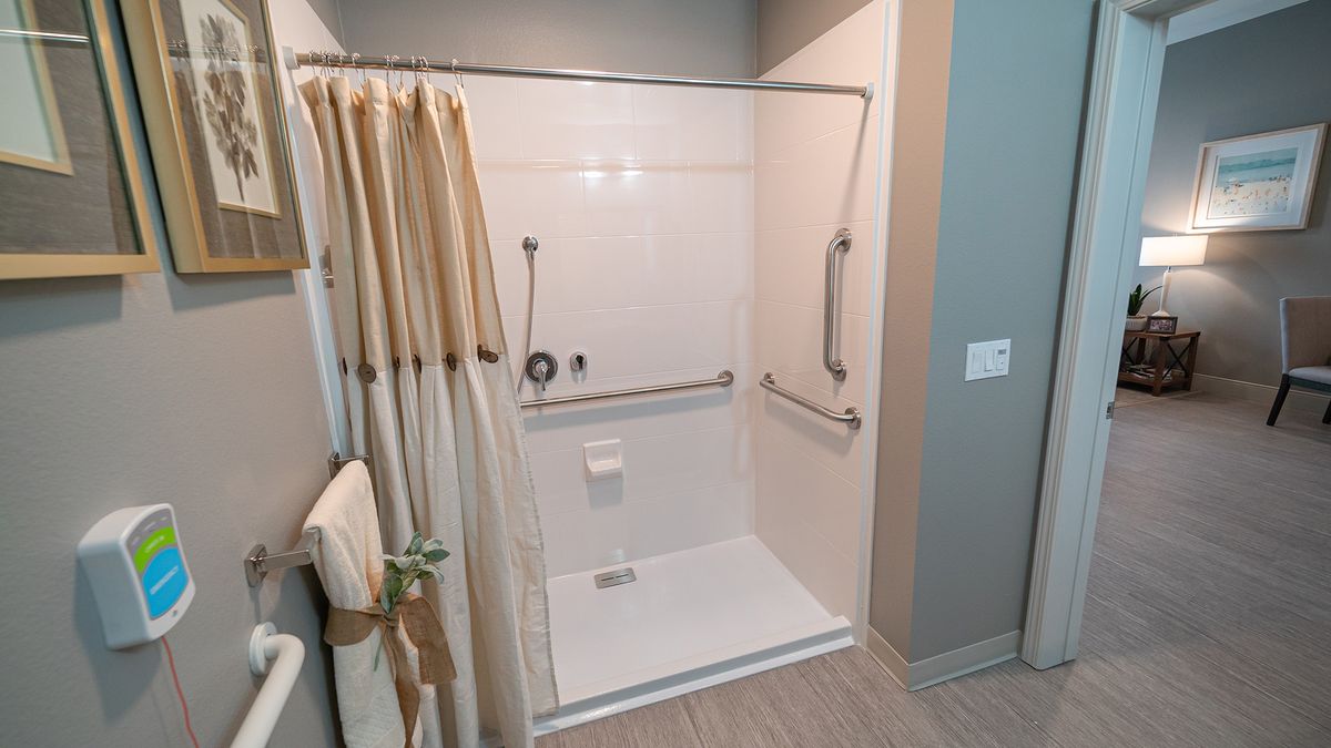 An accessible shower equipped with grab bars and a curtain for safety and privacy.