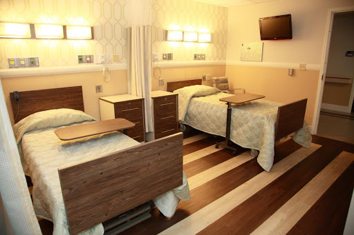A well-equipped hospital patient room featuring two beds, designed for comfort and functionality.
