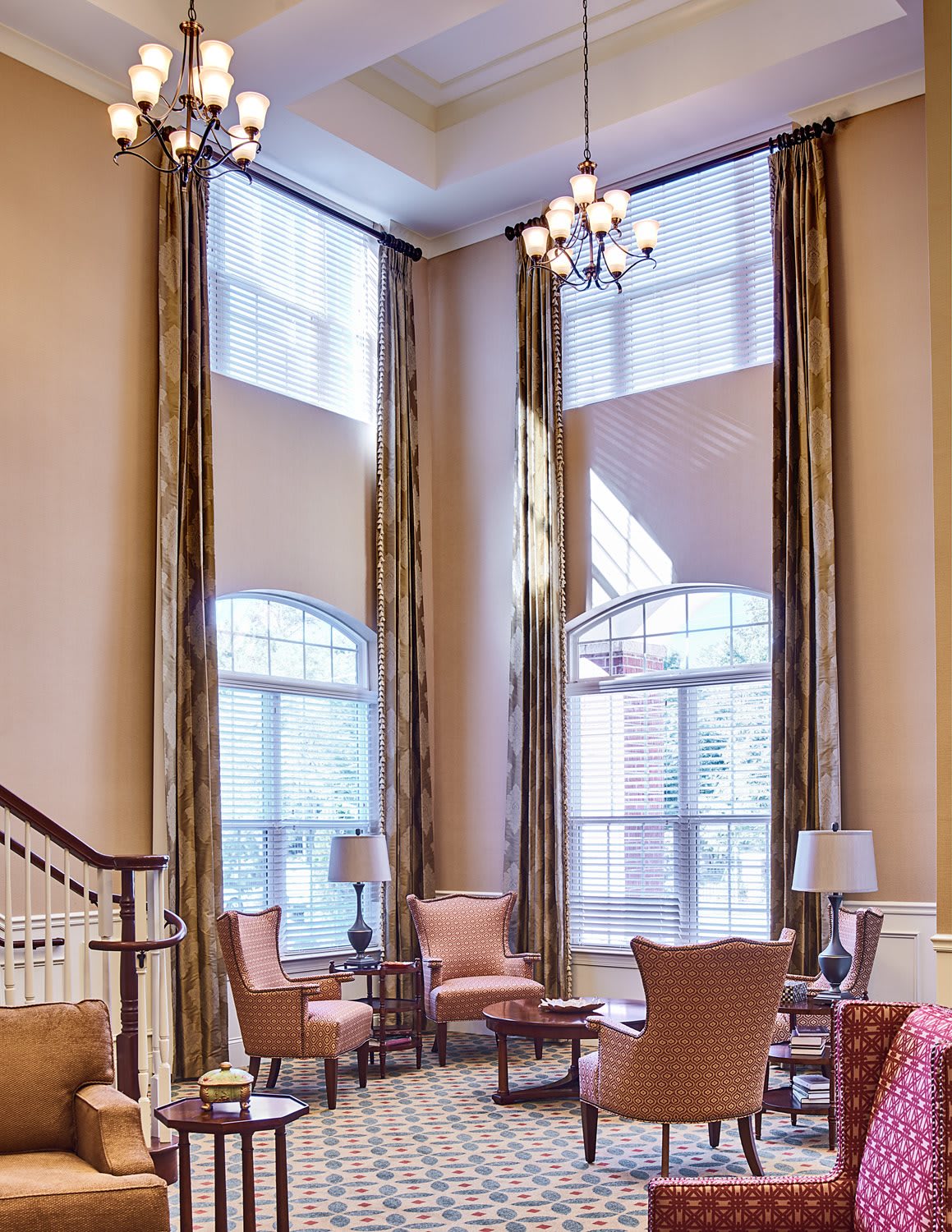 A spacious living room with high ceilings, large windows, and elegant decor.
