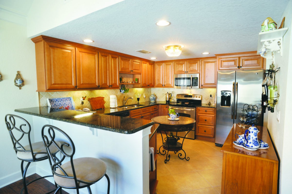 A modern kitchen with wooden cabinets, granite countertops, and stainless steel appliances.