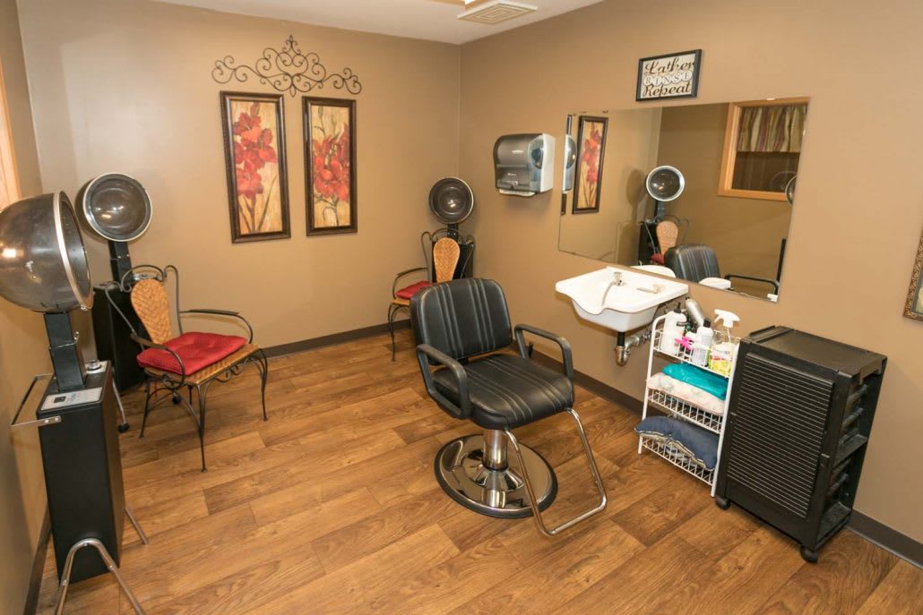 Interior view of a hair salon with styling chair and equipment.