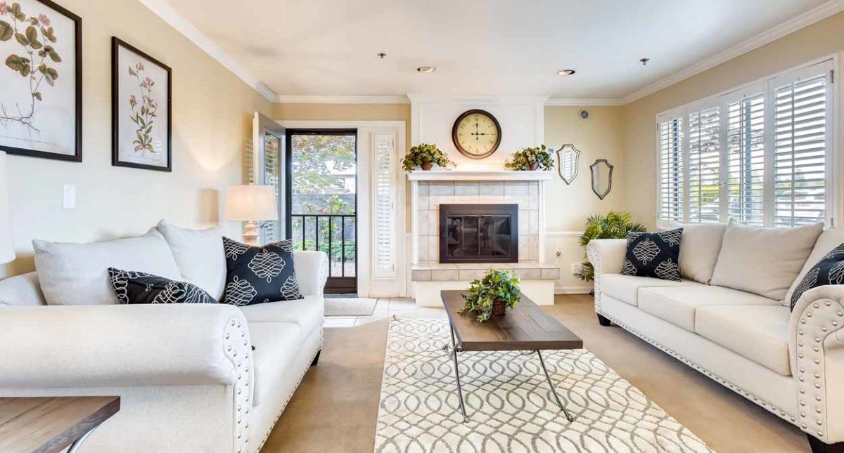 A cozy and elegantly decorated living room featuring a fireplace, comfortable sofas, a modern coffee table, and tasteful decor.