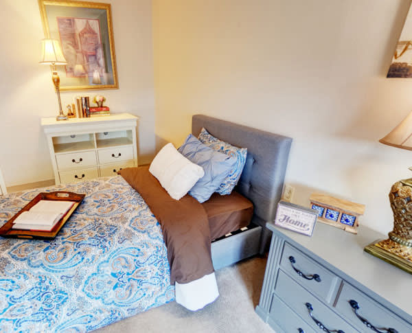 A cozy bedroom with a neatly made bed, nightstands, and decorative elements.