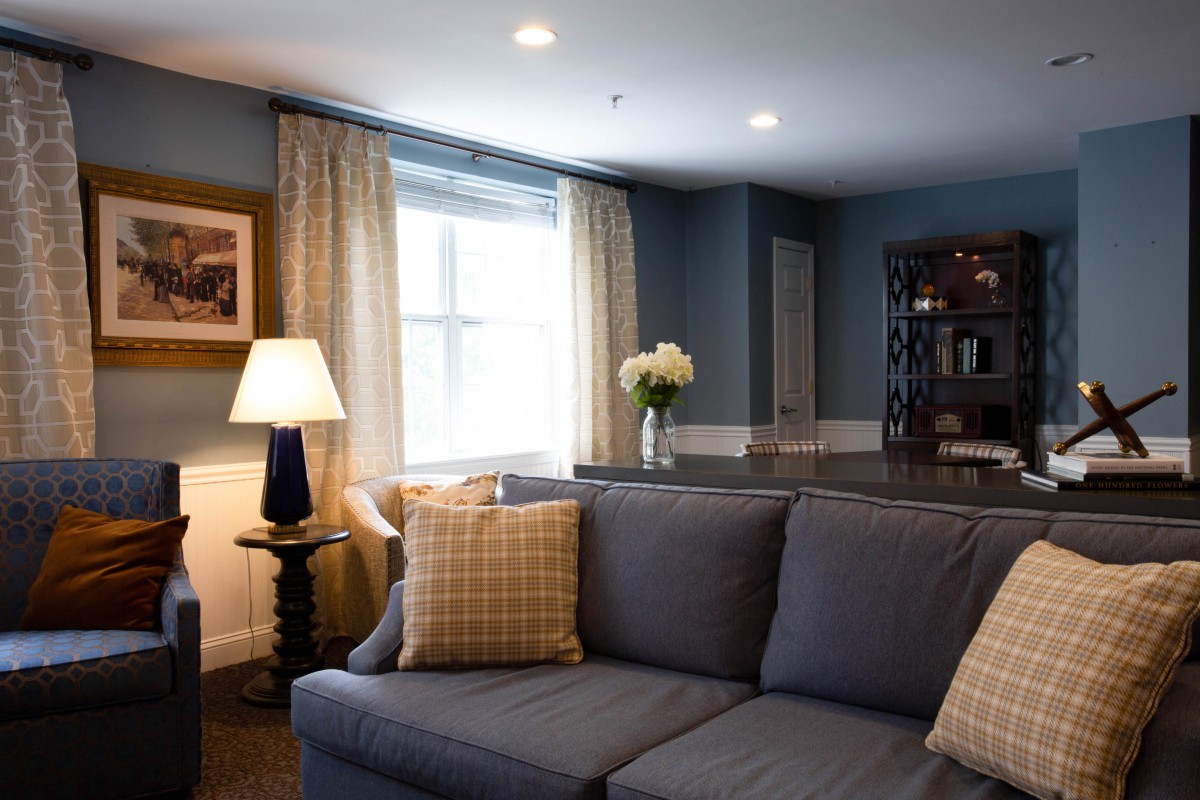 A cozy living room with a blue sofa, decorative cushions, and ambient lighting.