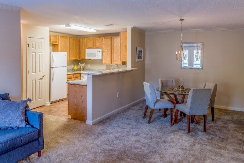 A modern apartment with an open floor plan featuring a kitchen and dining area.