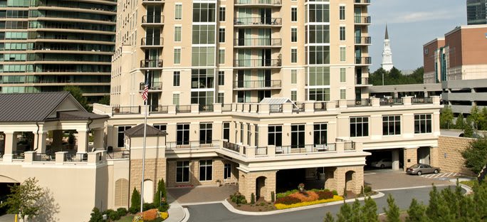 A modern residential apartment building with multiple floors and large windows.