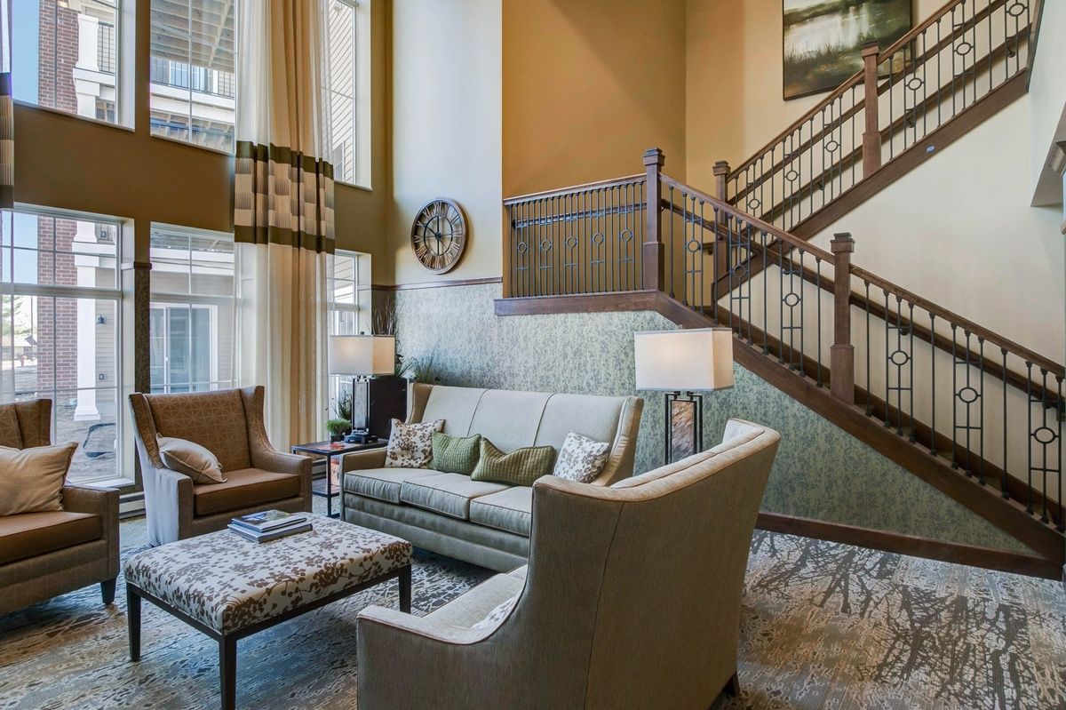 A cozy living room with elegant furniture and a wooden staircase.