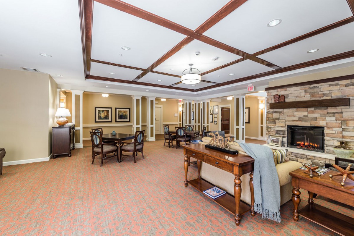 A spacious and elegantly designed living room with hardwood floors and ceiling beams.