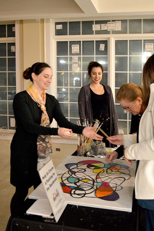 People engaging in an interactive art activity at an event.