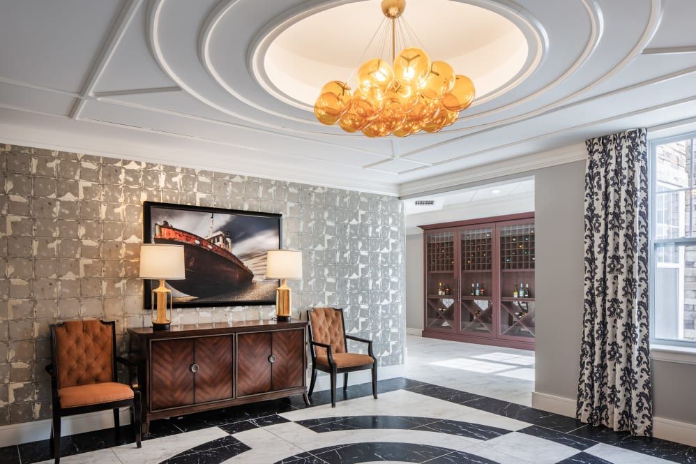 A luxurious foyer with an elegant chandelier and stylish furniture.