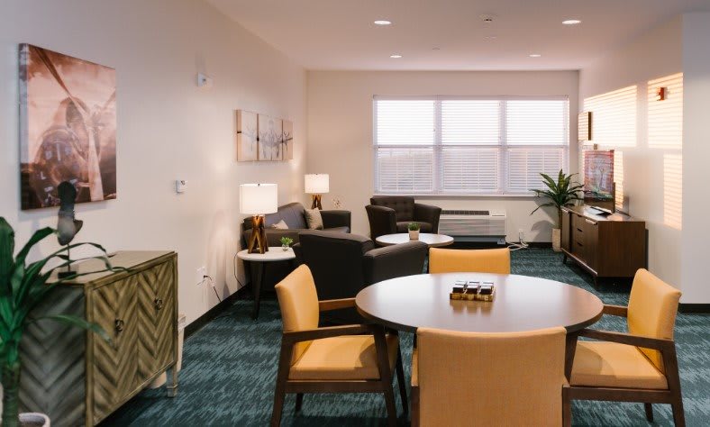A cozy living room with comfortable seating, a round table, and warm lighting.