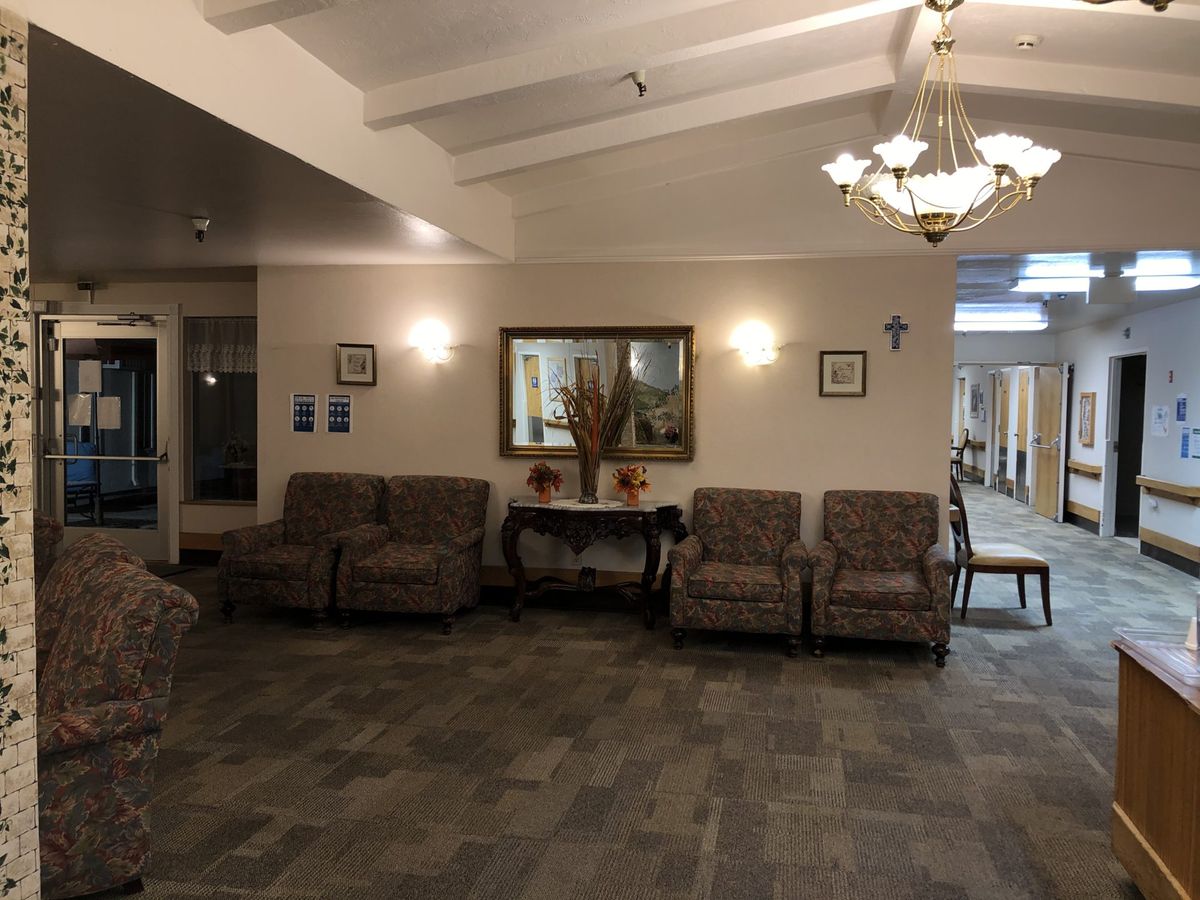 A cozy lobby area with sofas, a decorative mirror, and soft lighting.
