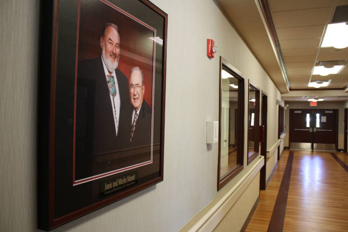 A hallway featuring a framed portrait of two individuals on the wall.