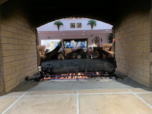 A warm and inviting view of a fireplace with glowing embers and stacked wood.