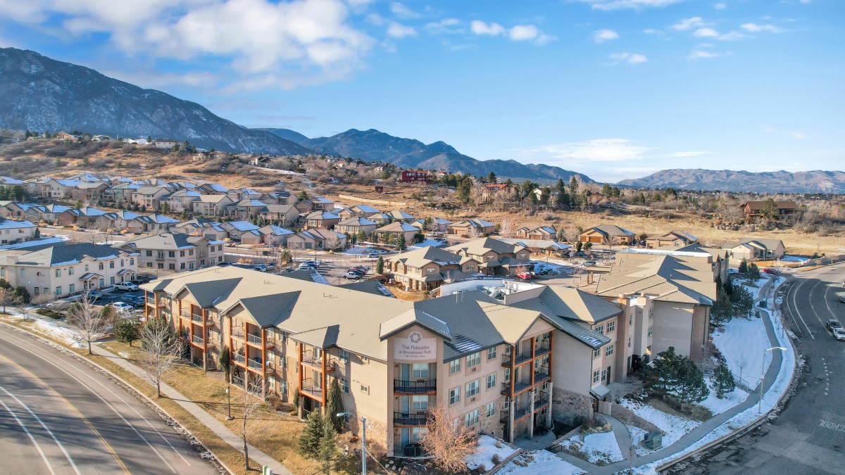 A scenic aerial view of a residential neighborhood with mountains in the background.