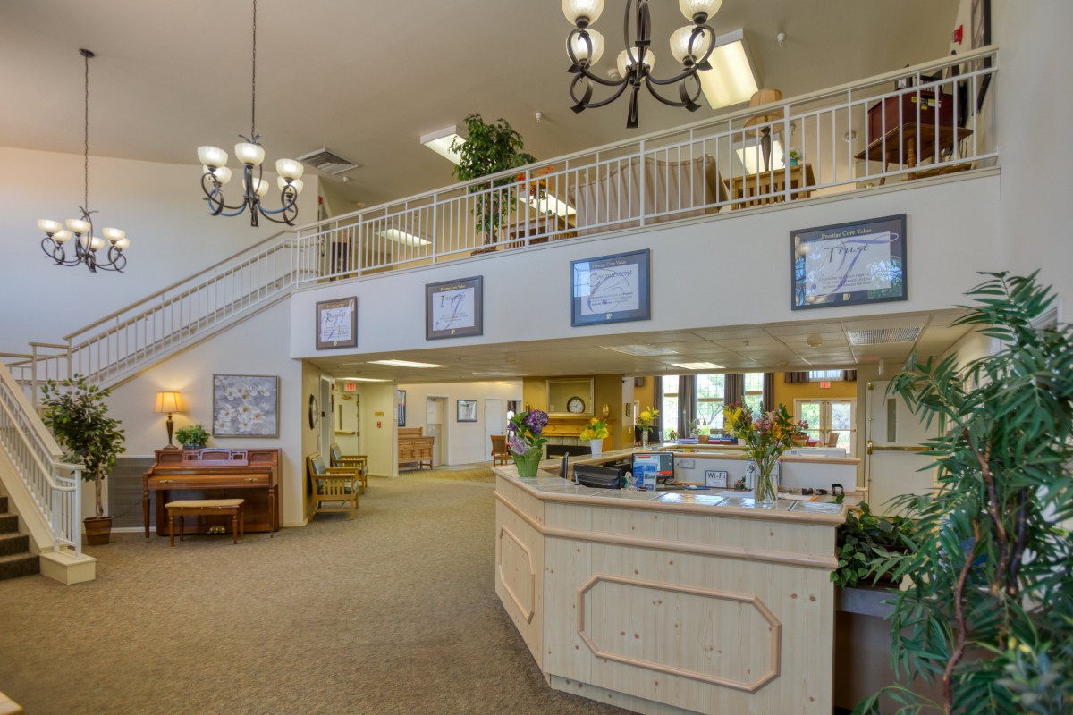 A spacious reception area with a desk, balcony, and elegant chandeliers.
