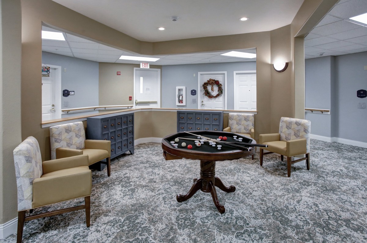 A modern lounge area with a game table and comfortable seating.