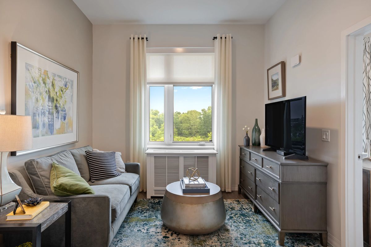 A cozy living room featuring a sofa, television, and a central coffee table with decor.