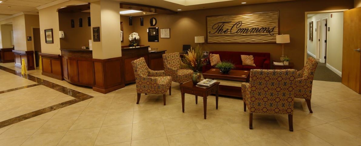 A cozy waiting room with patterned chairs and a central table adorned with flowers.