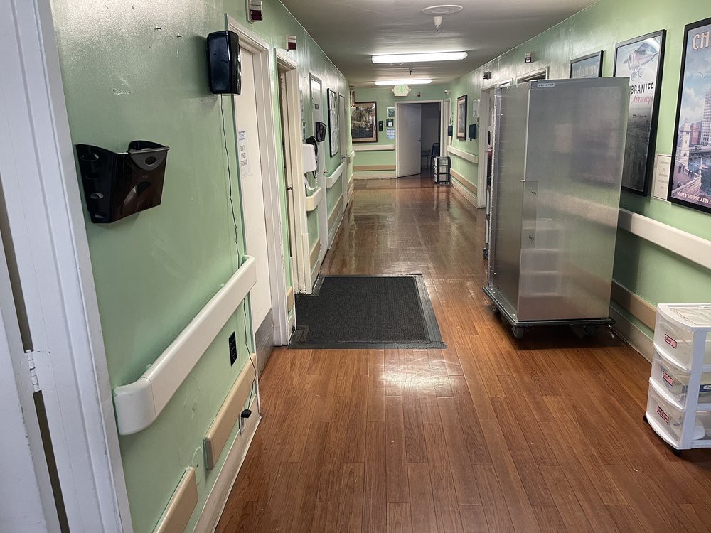 A hospital hallway with medical equipment and doors on either side.