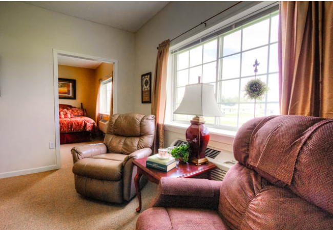A cozy living room with comfortable armchairs and a large window bringing in natural light.