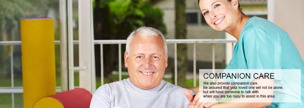 A smiling elderly man sitting outdoors in a casual setting.