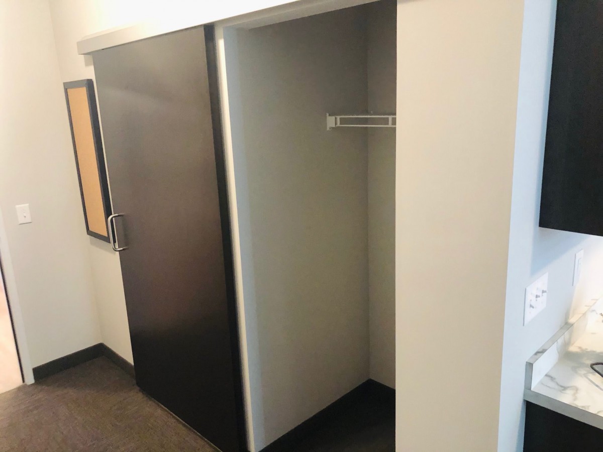 An empty minimalist closet with a single hanging rod.
