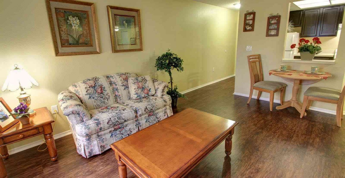 Cozy living room with a floral sofa, wooden coffee table, and decorative items.