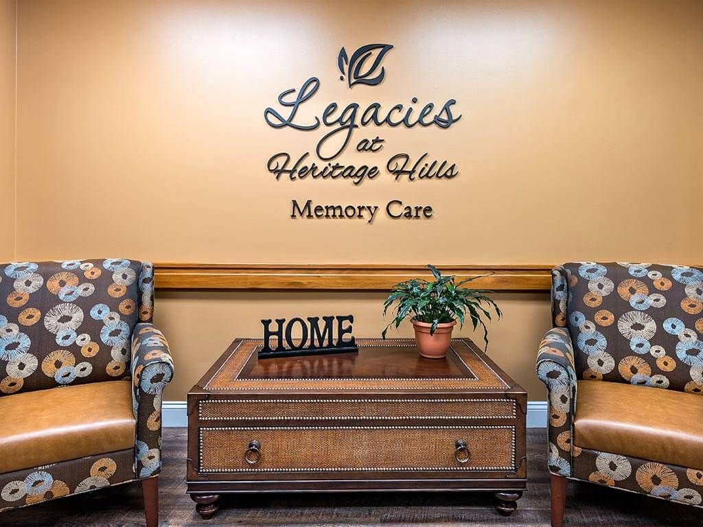 Cozy waiting area at Legacies at Heritage Hills Memory Care, featuring comfortable chairs and a decorative table.