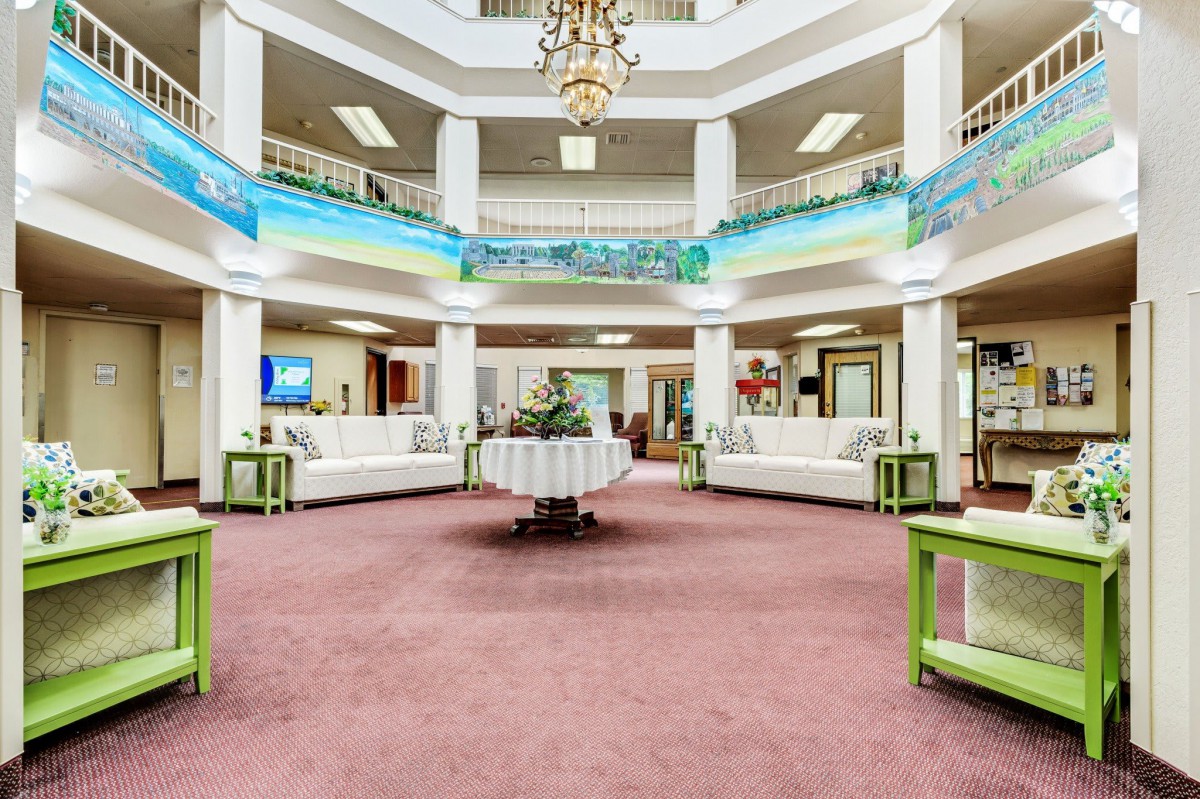 Spacious and elegant lobby with a chandelier and balcony.