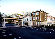 A modern residential building with an adjacent parking lot.