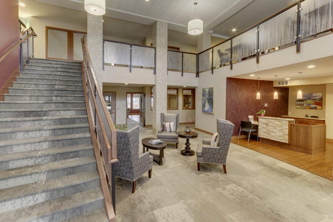 A modern hotel lobby with seating area and a reception desk.