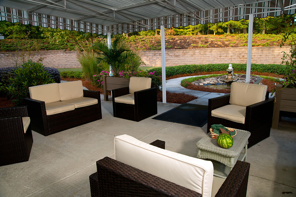 A cozy outdoor patio with comfortable seating and a landscaped garden.