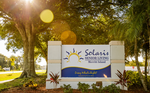 Welcoming sign for Solaris Senior Living, set against a lush outdoor backdrop.