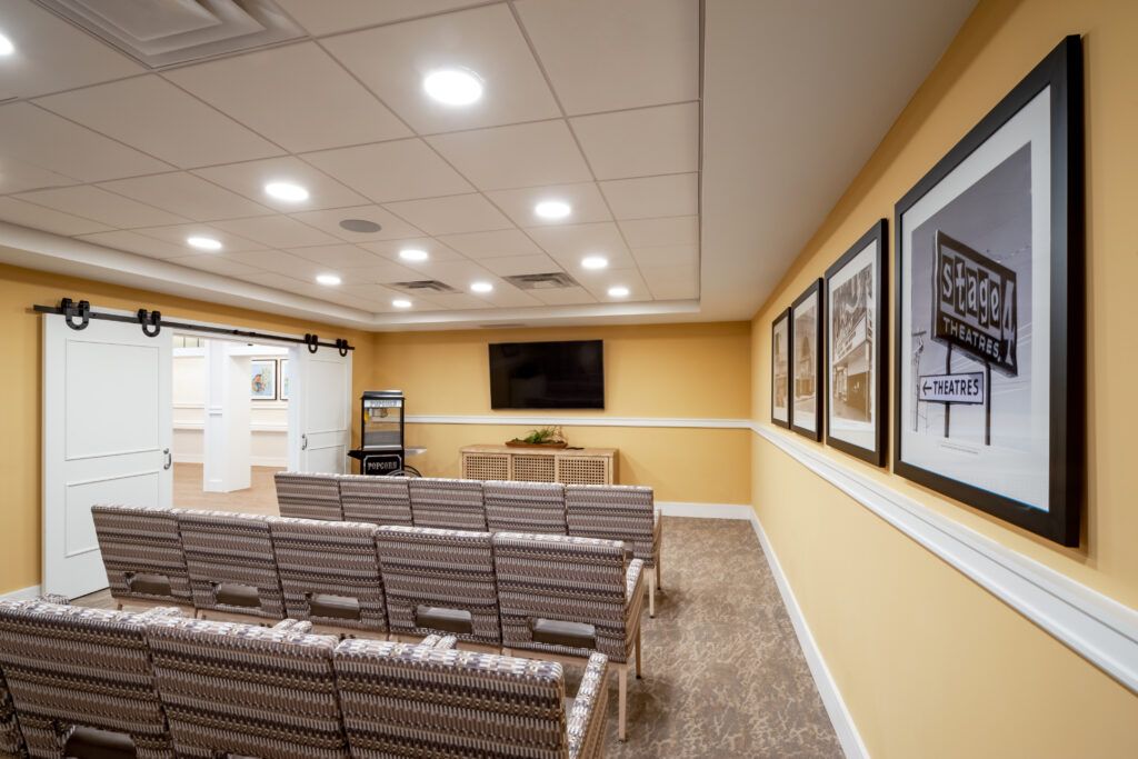 A neatly arranged conference room with rows of chairs facing a large television and projector screen.